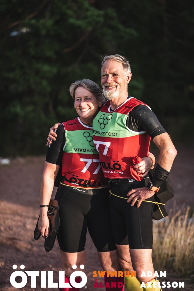 A man and woman stand next to each other in sports gear after completing a swimrun race.
