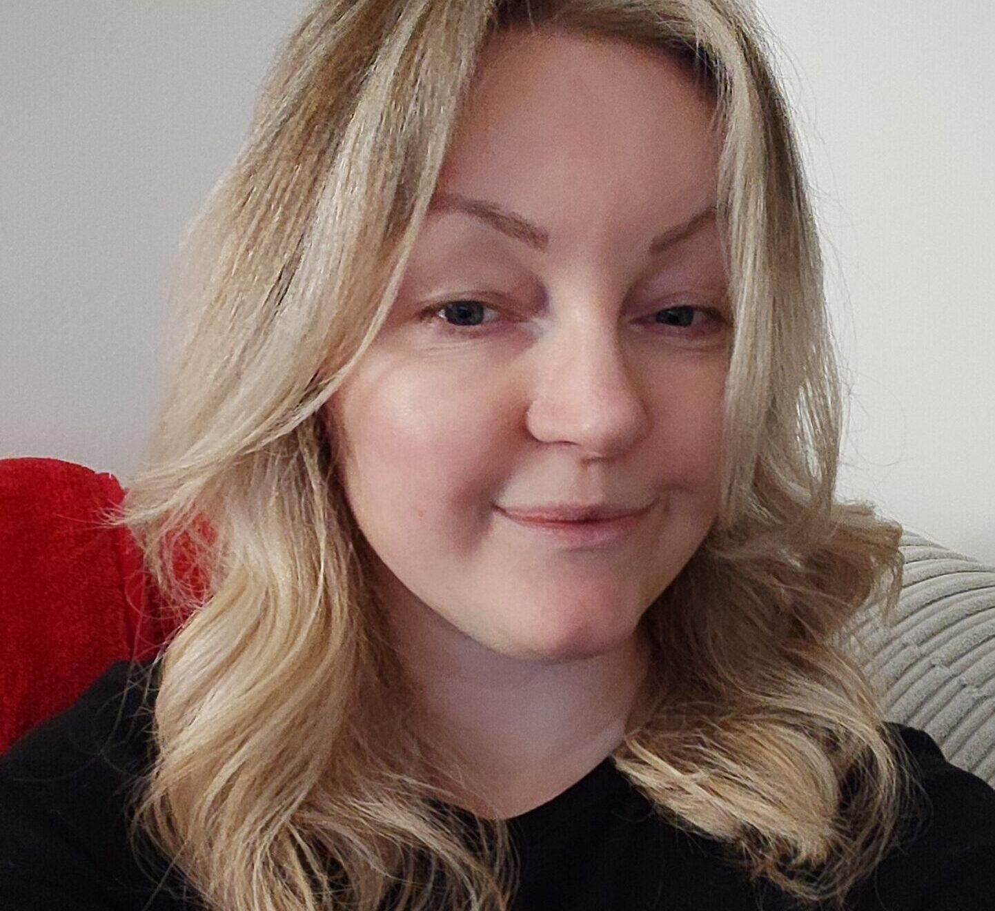 A woman with blond hair smiles at the camera.