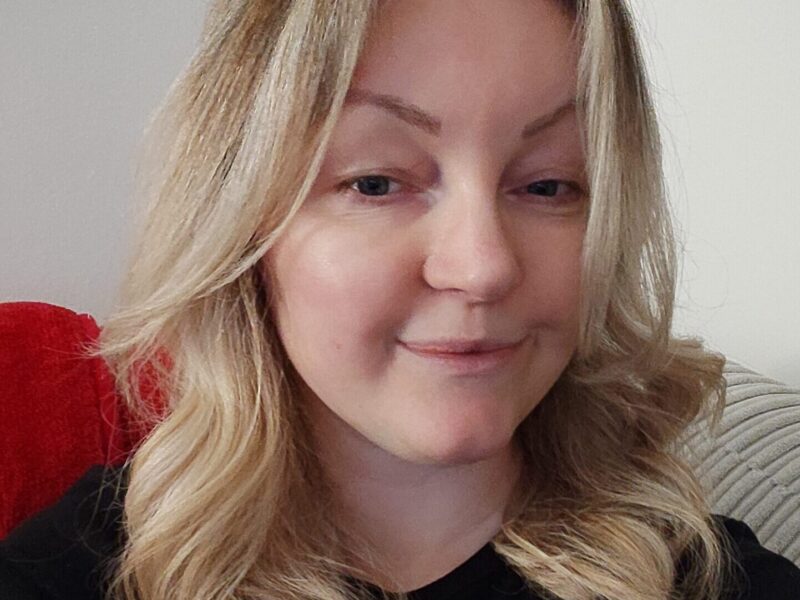A woman with blond hair smiles at the camera.
