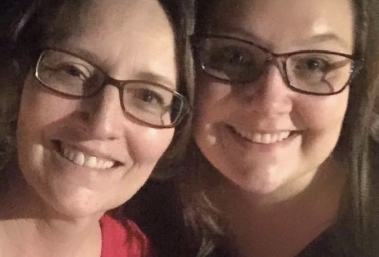 Mum and daughter smile at the camera.
